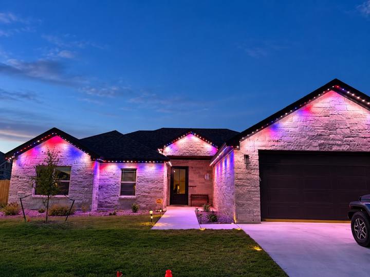 Red, white and blue lighting on a stone home at dusk