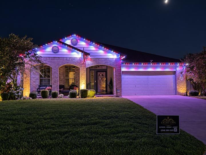 Red, white and blue roofline lighting on a brick home