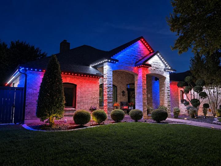 Red and blue 4th of July lighting on a brick and stone home