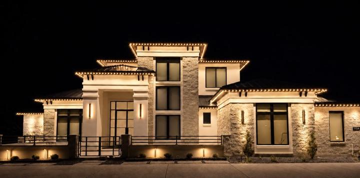 Warm white accent lighting on a modern stone home