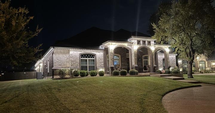 White accent lighting on a stone and brick home