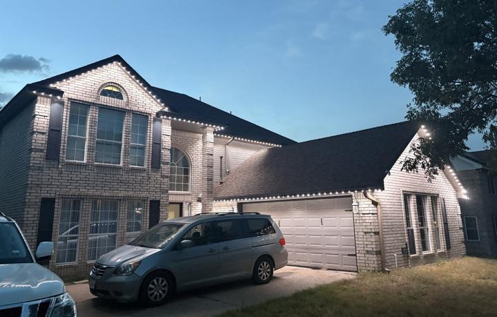 White roofline accent lighting on a two-story brick home