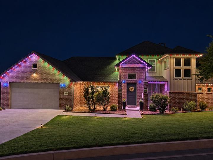 Multicolor Christmas lighting on a brick home with a two-story entry